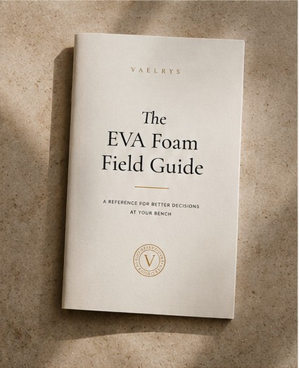 The EVA Foam Field Guide — a slim cream booklet with gold seal, lying flat on warm stone